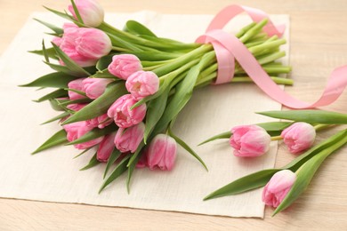 Photo of Bouquet of beautiful tulips on wooden table, closeup