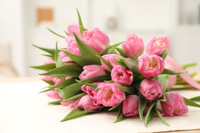 Photo of Bouquet of beautiful tulips on table indoors, closeup