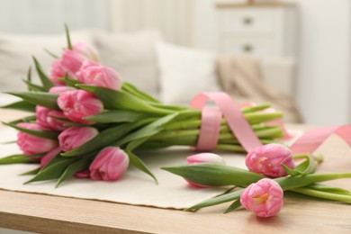 Photo of Bouquet of beautiful tulips on wooden table indoors, closeup