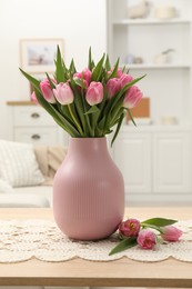 Photo of Bouquet of beautiful tulips in vase on table indoors