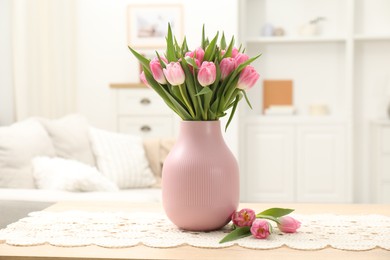 Photo of Bouquet of beautiful tulips in vase on table indoors