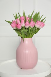 Photo of Bouquet of beautiful tulips in vase on white table indoors