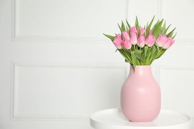 Photo of Bouquet of beautiful tulips in vase on white table indoors, space for text