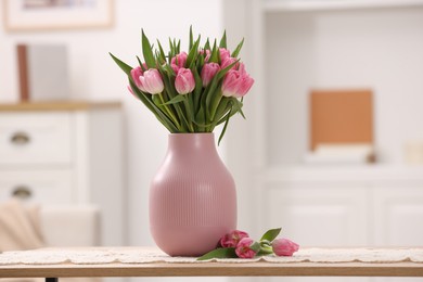 Photo of Bouquet of beautiful tulips in vase on table indoors