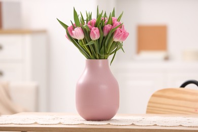 Photo of Bouquet of beautiful tulips in vase on table indoors