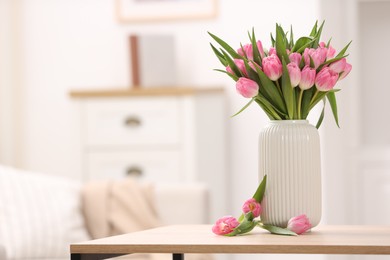 Photo of Bouquet of beautiful tulips in vase on wooden table indoors, space for text