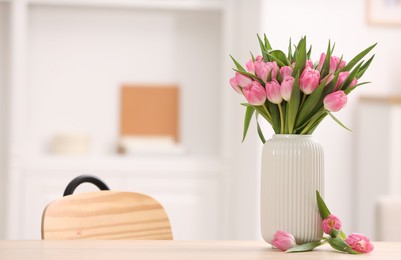 Photo of Bouquet of beautiful tulips in vase on wooden table indoors, space for text