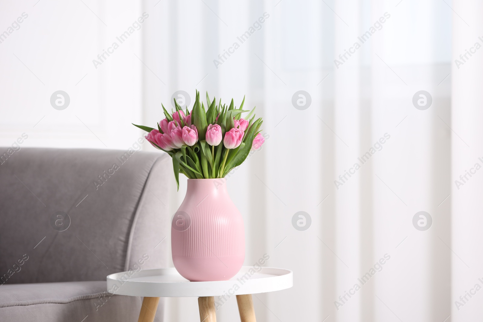 Photo of Bouquet of beautiful tulips in vase on table indoors, space for text