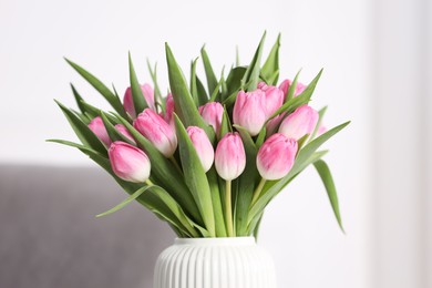 Photo of Bouquet of beautiful tulips in vase indoors, closeup