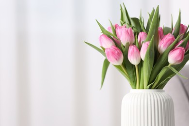 Photo of Bouquet of beautiful tulips in vase indoors, closeup. Space for text