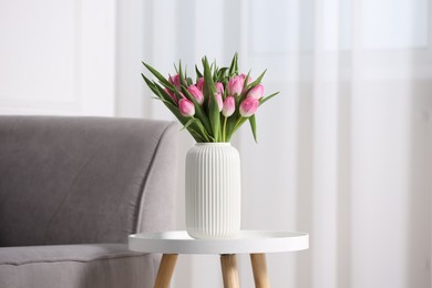 Photo of Bouquet of beautiful tulips in vase on table indoors