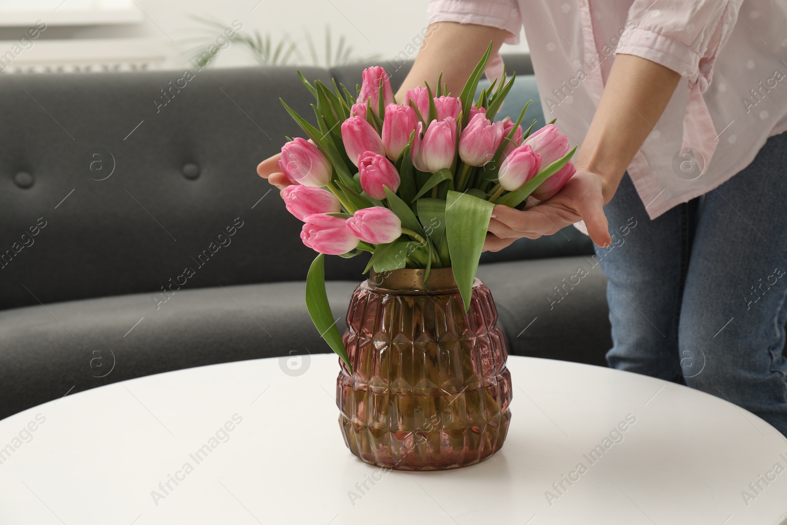 Photo of Woman with bouquet of beautiful tulips indoors, closeup. Space for text