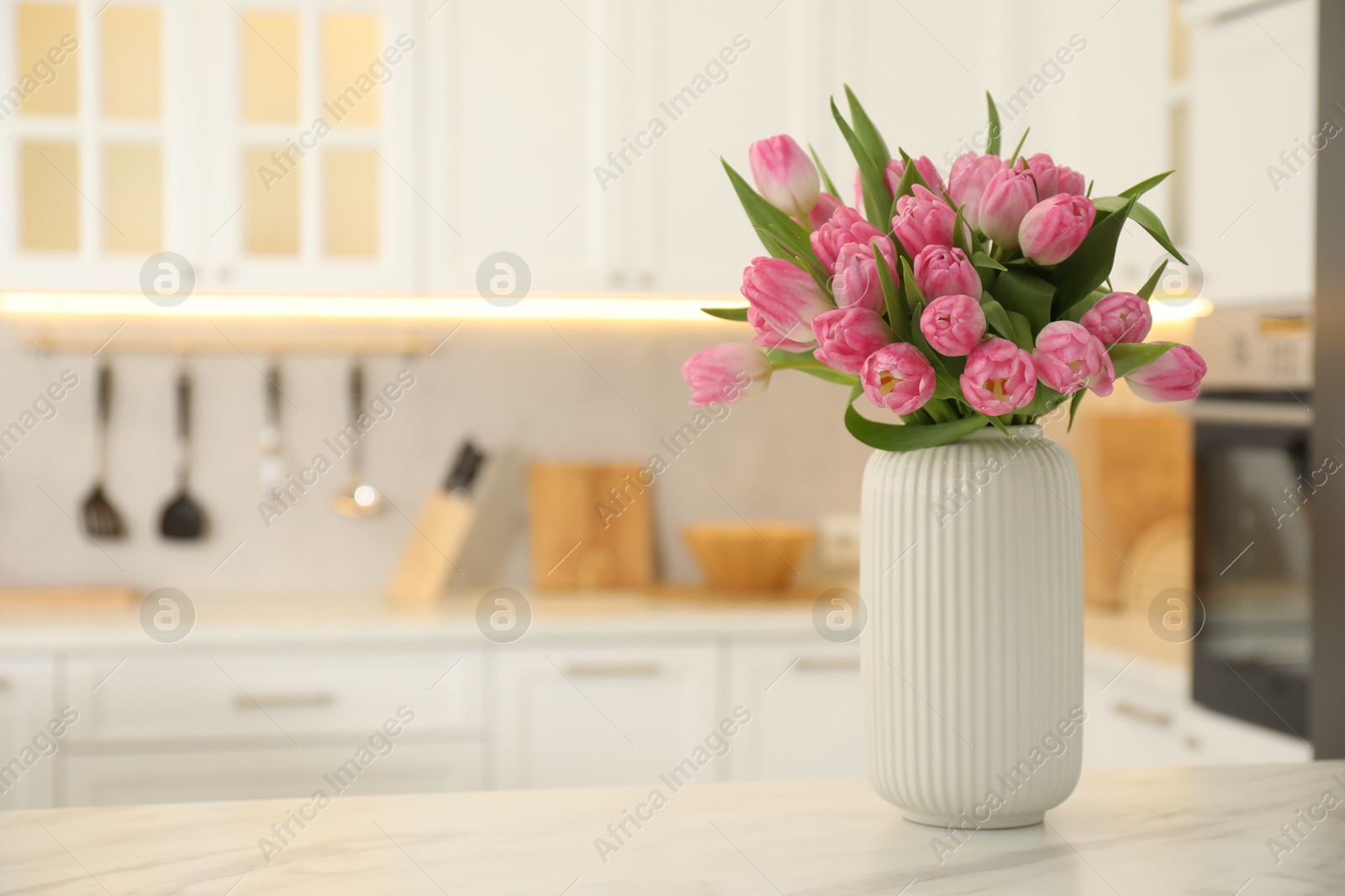 Photo of Bouquet of beautiful tulips in vase on white marble table indoors, space for text