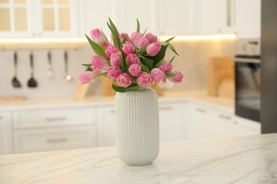 Photo of Bouquet of beautiful tulips in vase on white marble table indoors