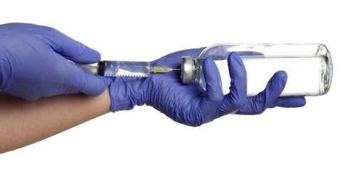 Photo of Doctor in medical gloves filling syringe with medication on white background, closeup