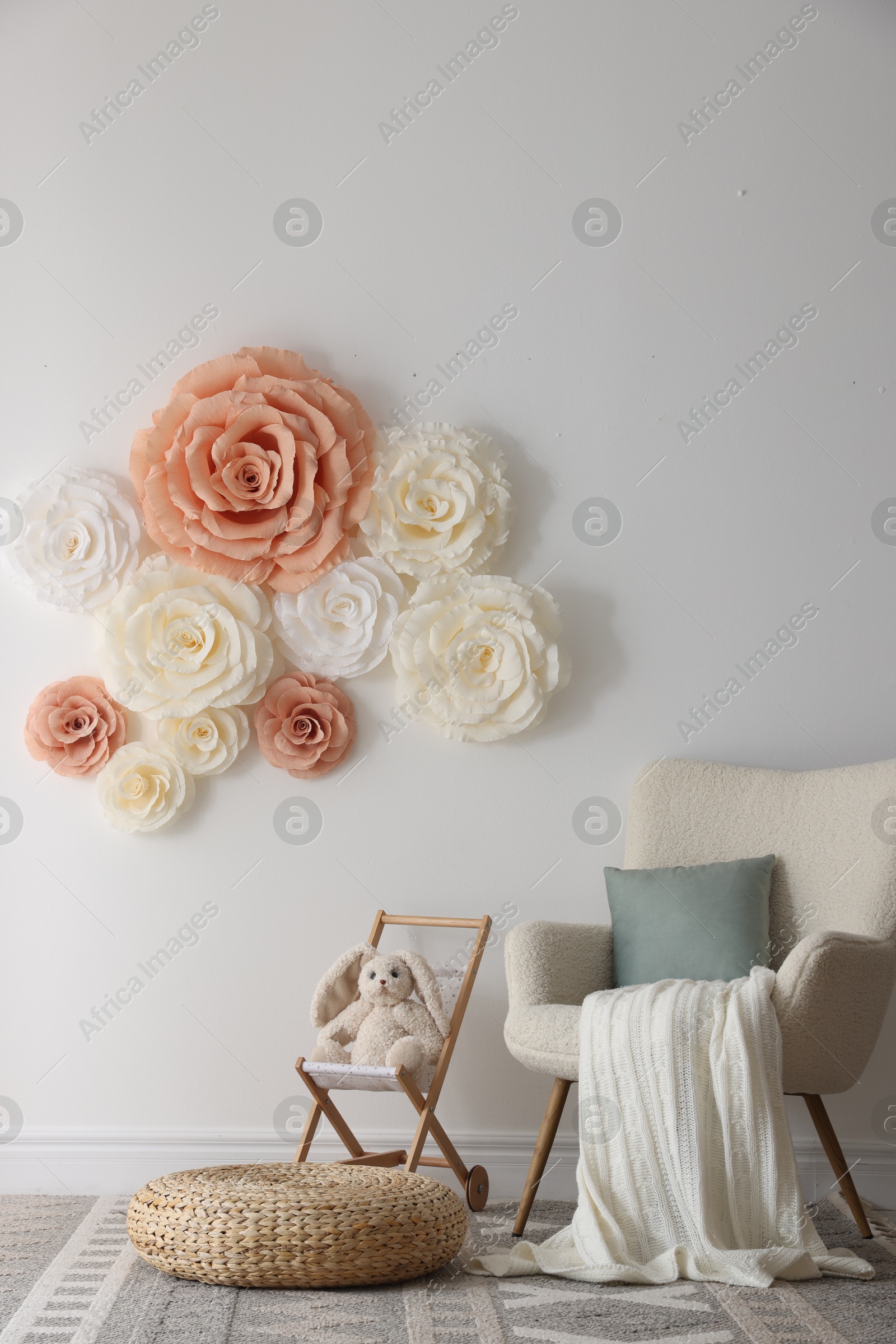 Photo of Beautiful decorative paper flowers on white wall in child's room