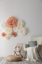 Photo of Beautiful decorative paper flowers on white wall in child's room