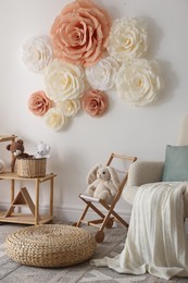 Photo of Beautiful decorative paper flowers on white wall in child's room