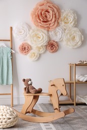 Photo of Beautiful decorative paper flowers on white wall in child's room