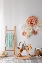 Photo of Beautiful decorative paper flowers on white wall in child's room