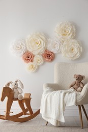 Photo of Beautiful decorative paper flowers on white wall in child's room