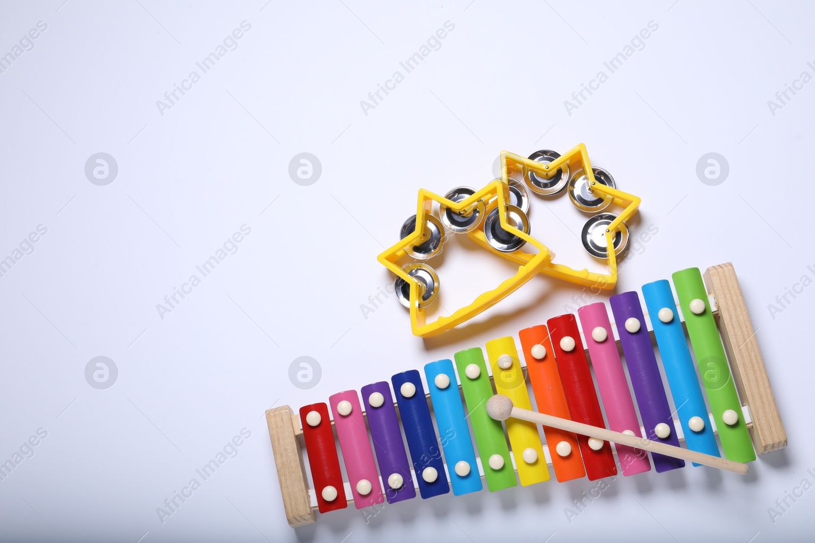 Photo of Colorful toy xylophone and tambourines on white background, flat lay. Space for text