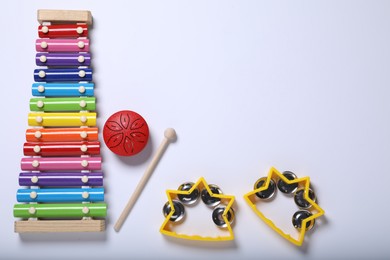 Flat lay composition with different toy musical instruments on white background. Space for text