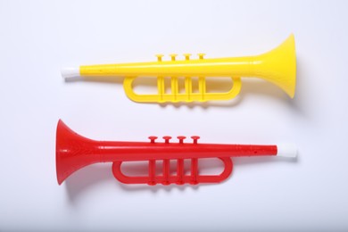 Colorful toy horns on white background, flat lay