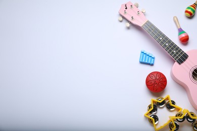 Flat lay composition with different toy musical instruments on white background. Space for text