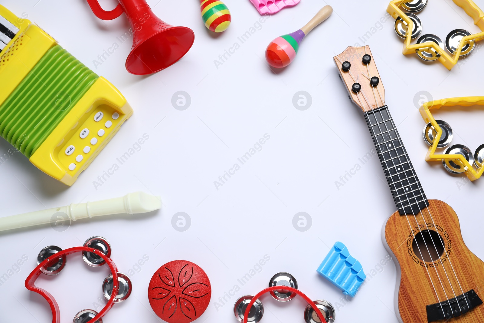 Photo of Frame of different toy musical instruments on white background, flat lay. Space for text