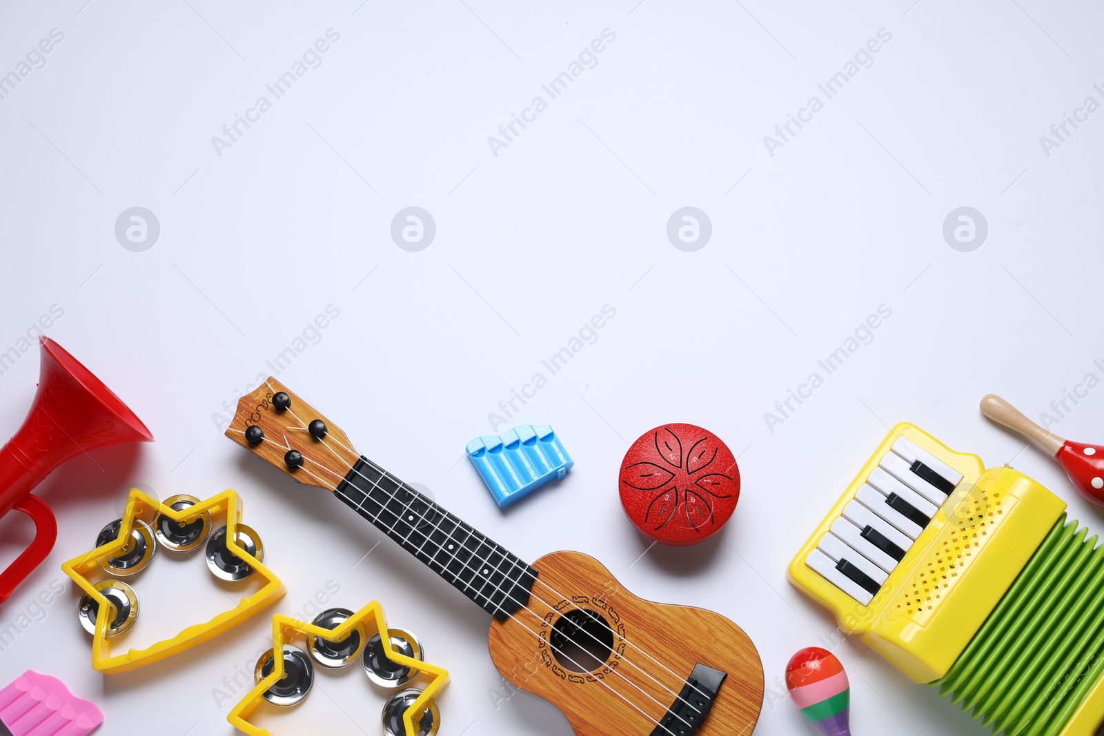 Photo of Flat lay composition with different toy musical instruments on white background. Space for text