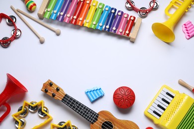 Flat lay composition with different toy musical instruments on white background. Space for text