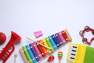 Flat lay composition with different toy musical instruments on white background. Space for text