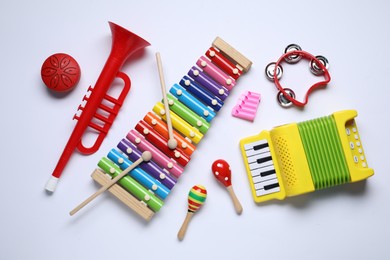 Flat lay composition with different toy musical instruments on white background