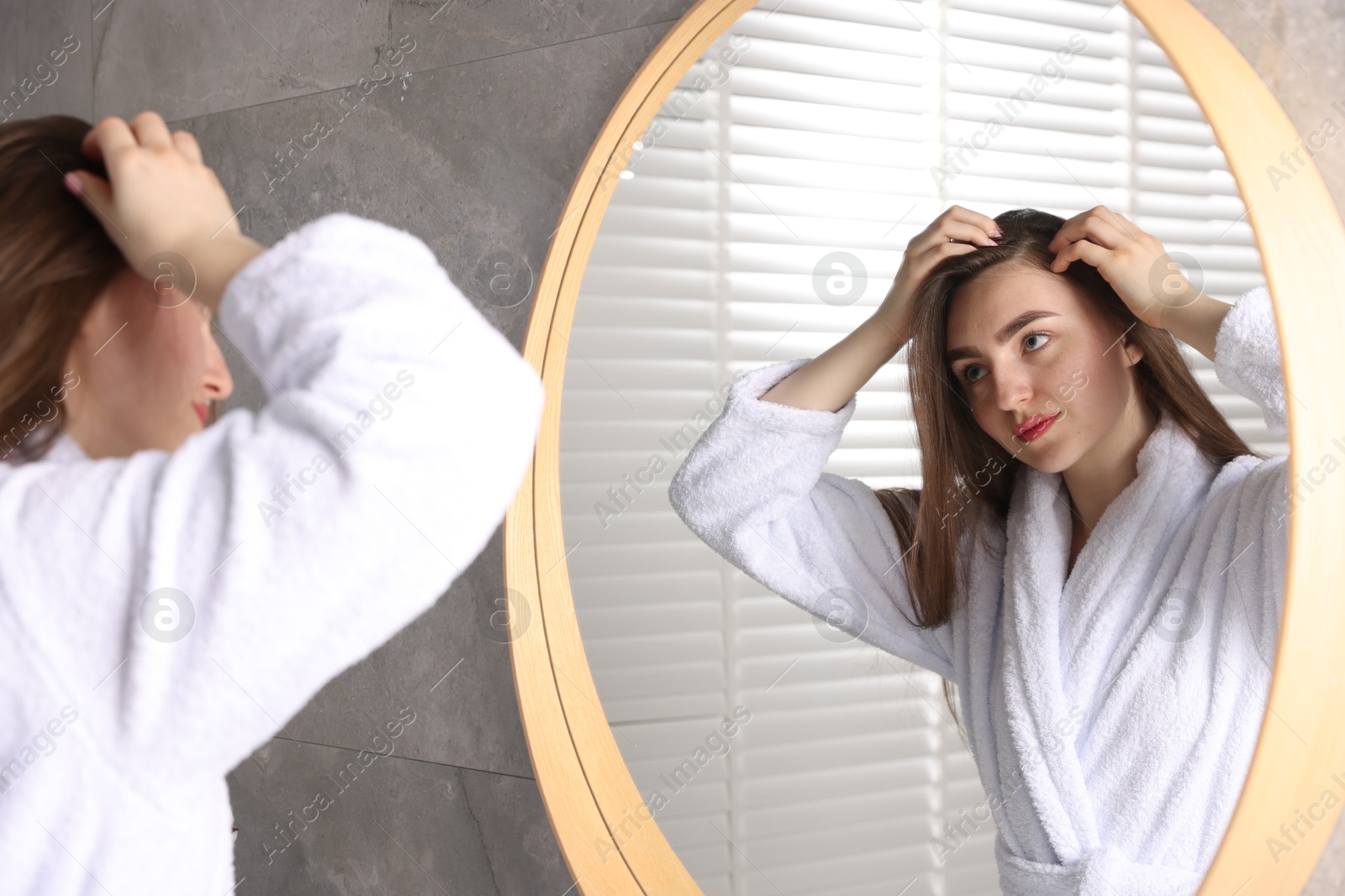 Photo of Beautiful woman with healthy hair roots near mirror at home