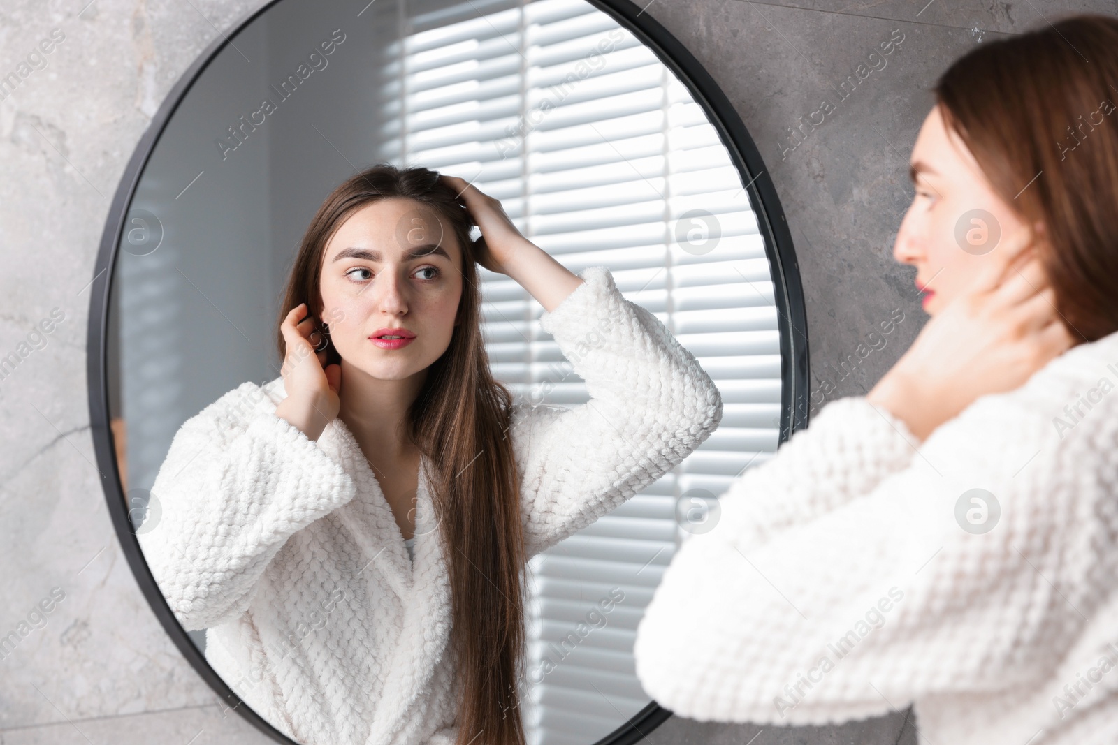 Photo of Beautiful woman with healthy hair roots near mirror at home