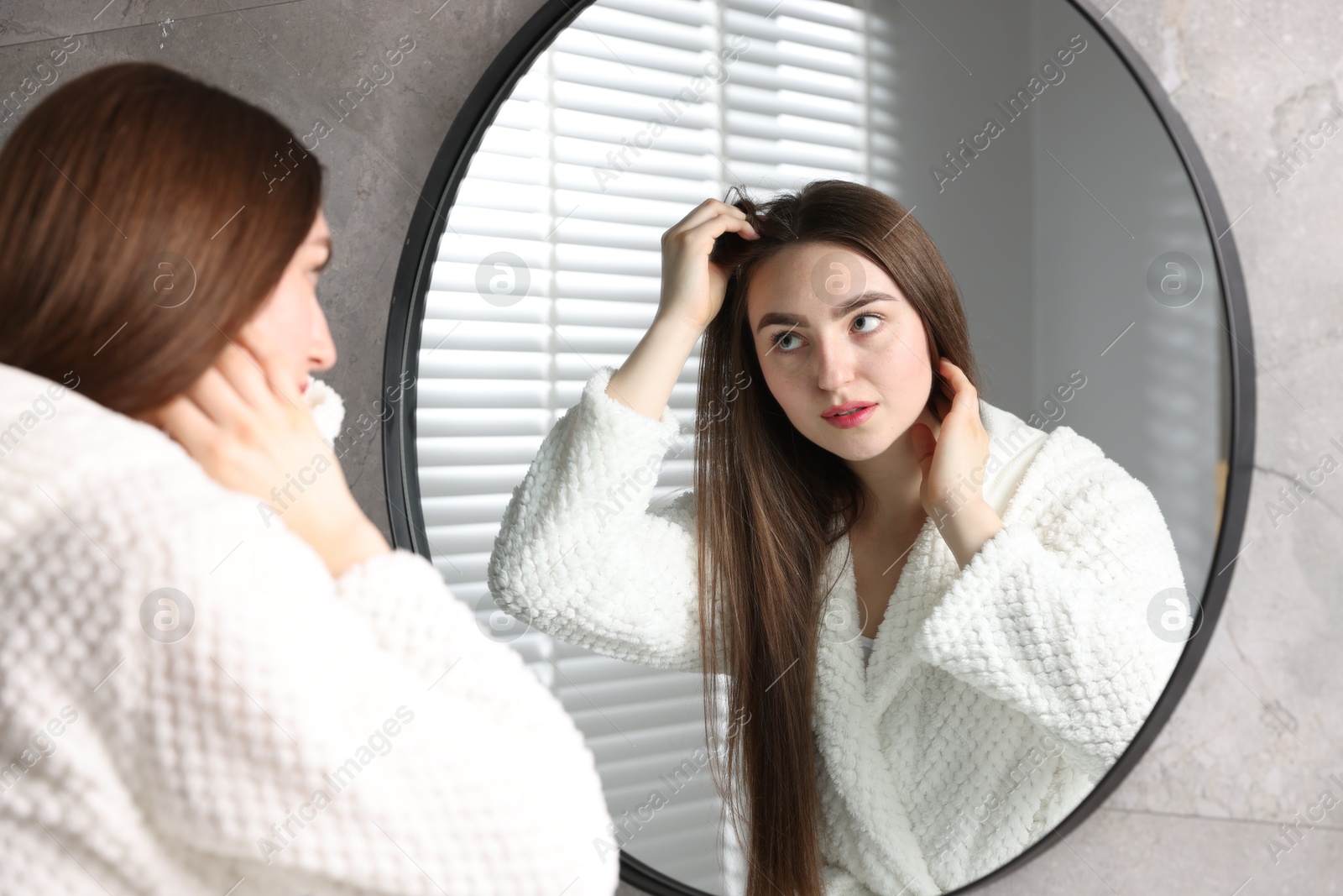 Photo of Beautiful woman with healthy hair roots near mirror at home