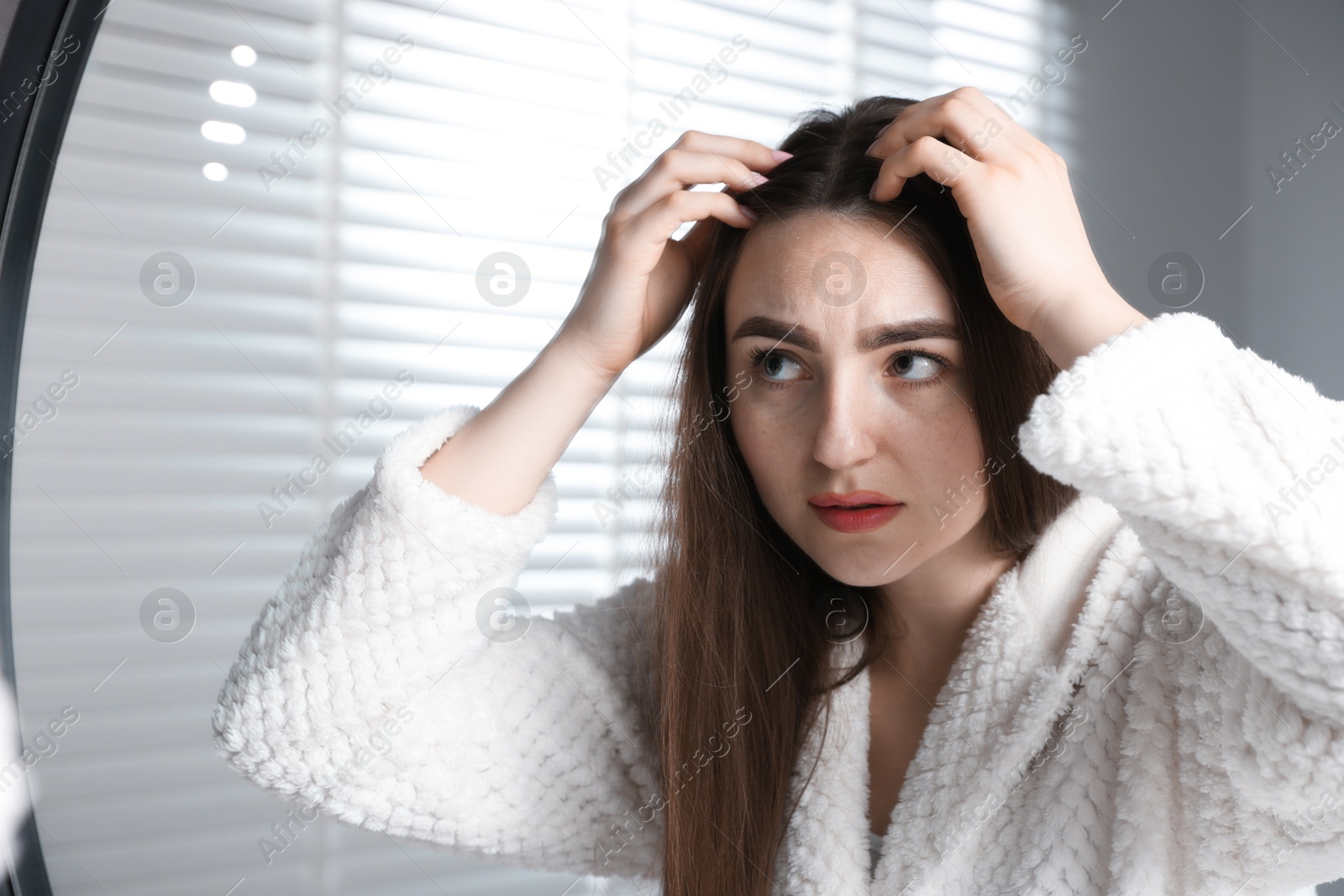 Photo of Beautiful woman with healthy hair roots near mirror at home