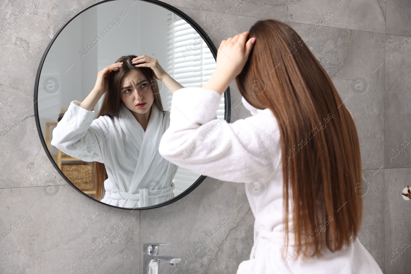 Photo of Beautiful woman with healthy hair roots near mirror at home