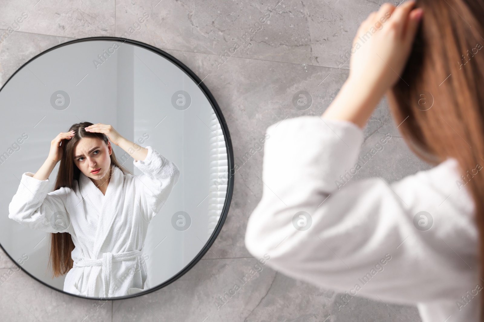 Photo of Beautiful woman with healthy hair roots near mirror at home