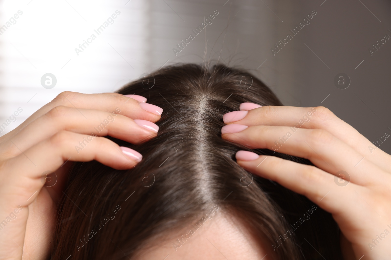 Photo of Woman with healthy hair roots on blurred background, closeup