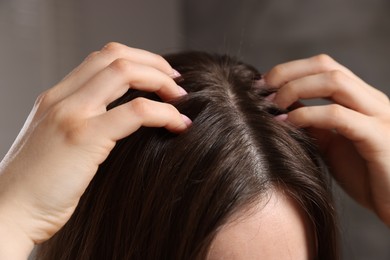 Photo of Woman with healthy hair roots on blurred background, closeup