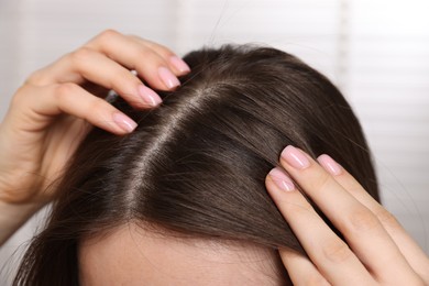 Woman with healthy hair roots on blurred background, closeup