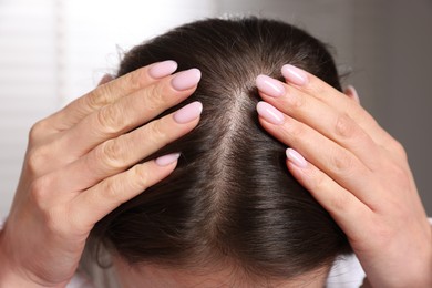 Woman with healthy hair roots on blurred background, closeup