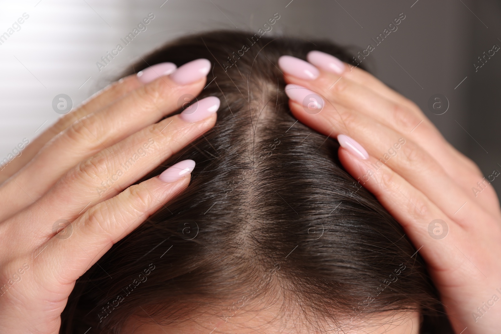 Photo of Woman with healthy hair roots on blurred background, closeup