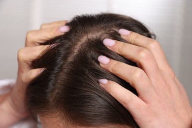 Woman with healthy hair roots on blurred background, closeup