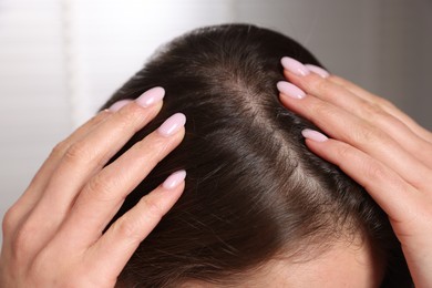 Woman with healthy hair roots on blurred background, closeup