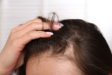 Photo of Woman with healthy hair roots on blurred background, closeup