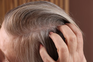 Senior woman with healthy hair roots on blurred background, closeup