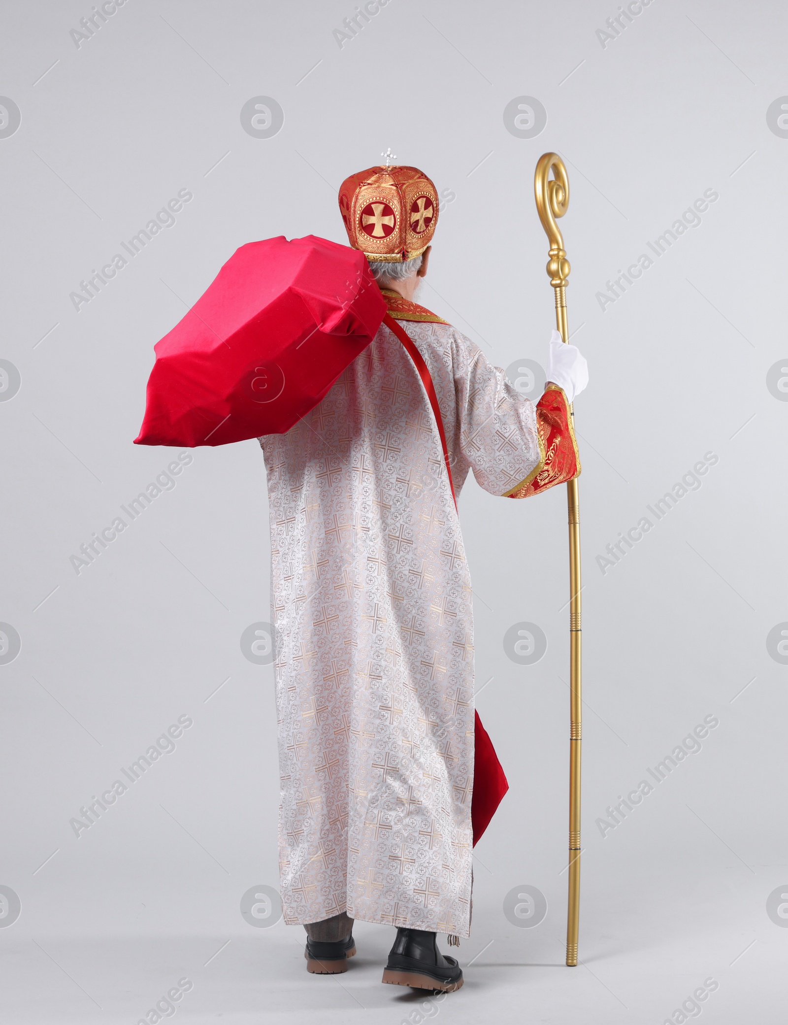 Photo of Saint Nicholas with sack on light grey background, back view